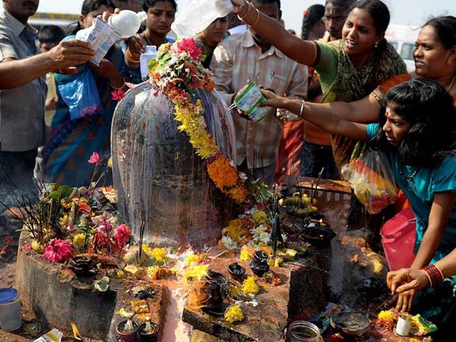 Hindu devotees offer prayers to a Shiva Lingam, a stone sculpture representing the phallus of Hindu god Lord Shiva, on Maha Shivaratri at the Keesaragutta Temple on the outskirts of Hyderabad. AFP/Noah Seelam